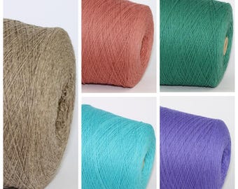 May include: Five skeins of yarn in different colours: brown, coral, green, turquoise, and purple. The yarn is wound into balls and is ready for knitting or crocheting.