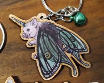 Keychain, Charm or Strap of a Super cute Fairy Piglet with moon moth wings Illustration Printed on wood