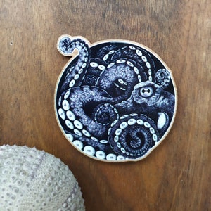 Magnet of an Octopus with its tentacle out printed on wood