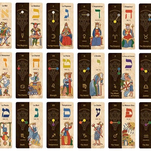 May include: A set of 22 tarot cards with Hebrew letters and astrological symbols. Each card features a colorful illustration with a black and gold background.