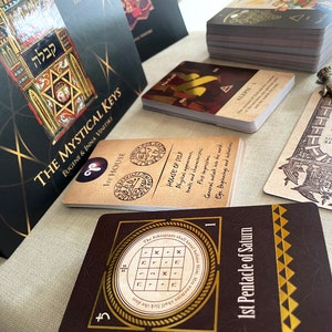 May include: A set of tarot cards with a brown and gold design. The cards feature a pentagram, a star of David, and the text "The Mystical Keys".