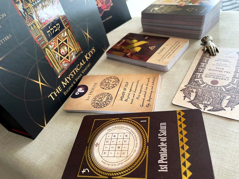 May include: A set of tarot cards with a brown and gold design. The cards feature a pentagram, a star of David, and the text "The Mystical Keys".