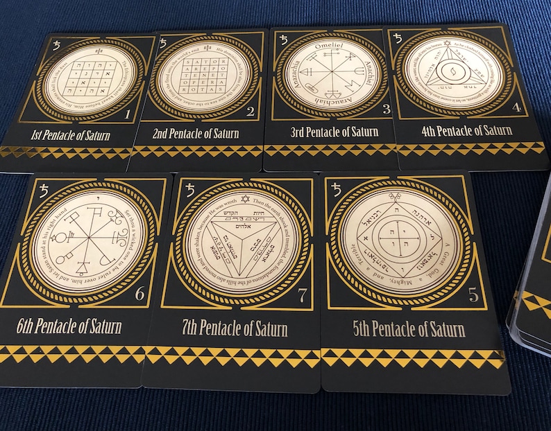 May include: Nine black cards with gold trim and text. Each card features a different symbol and text in Hebrew and English. The cards are numbered 1 through 9. The text on the cards reads "Pentacle of Saturn".