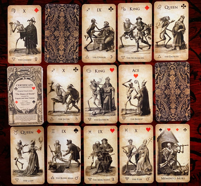 May include: A collection of tarot cards featuring illustrations of skeletons and figures in historical attire. The cards have a vintage aesthetic with detailed drawings and text. The deck includes a certificate of authenticity.