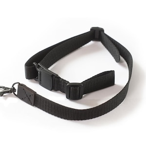 May include: A black camera strap with a leather accent and a metal clip. The strap has a buckle for adjusting the length.