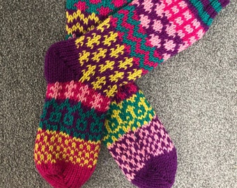 May include: A pair of colorful knitted socks with a geometric pattern in shades of pink, purple, yellow, and green.