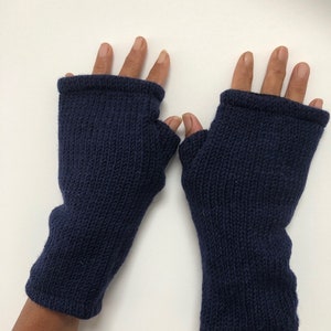 May include: A pair of navy blue fingerless knitted gloves. The gloves are made of a soft, warm material and are perfect for keeping your hands warm in the winter.