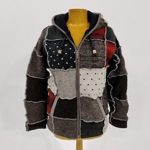 May include: A brown, gray, and black patchwork hooded jacket with a zipper closure. The jacket is made of a soft, knitted fabric and has a relaxed fit.