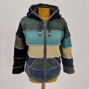 May include: A multi-colored knitted hooded jacket with a zipper closure. The jacket is made of different colored knitted panels, including green, blue, beige, and brown. The hood is lined with a gray fabric.