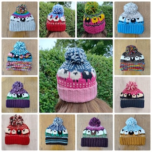 May include: A selection of hand-knitted woolly hats, each adorned with a sheep motif and a fluffy pom-pom. The hats display a variety of colours, such as blue, red, and purple, with contrasting pom-poms. These hats are designed for warmth and style.