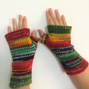 May include: A pair of colorful fingerless gloves with a striped pattern in shades of red, green, yellow, and black. The gloves are made of knitted wool.