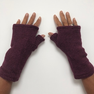 May include: A pair of burgundy fingerless gloves made of knitted wool.