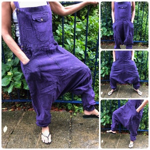 Op de afbeelding: Paarse katoenen overalls met een wijde pijp en een losse pasvorm. De overalls hebben een enkele voorzak en verstelbare banden.