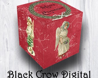 May include: A red cube-shaped box with a vintage Christmas design. The box features illustrations of angels and the text "Merry Christmas" within a wreath. Delicate snowflake and floral patterns decorate the surface. The text "Black Crow Digital" is at the bottom.