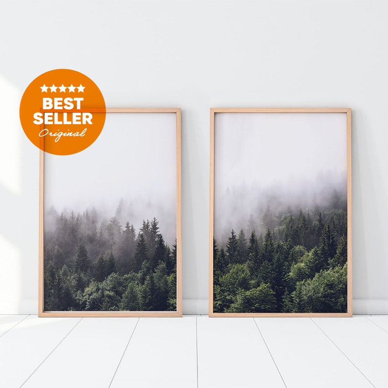 May include: Two framed prints of a misty forest scene. The prints are in wooden frames and are hanging on a white wall.