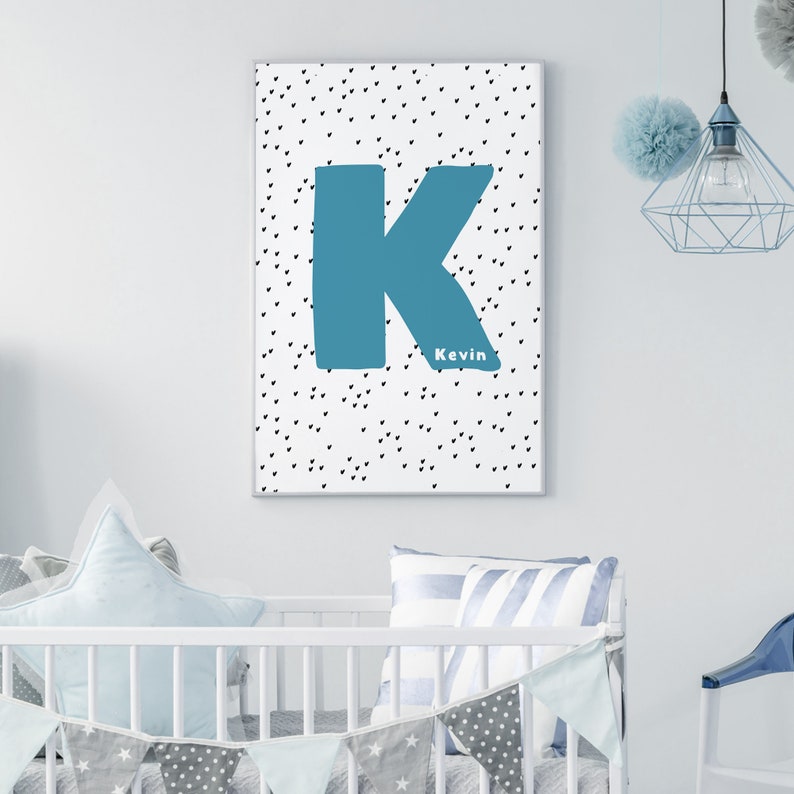 May include: A white canvas print with a blue letter K and the name Kevin in black text. The background is a white canvas with a black polka dot pattern.