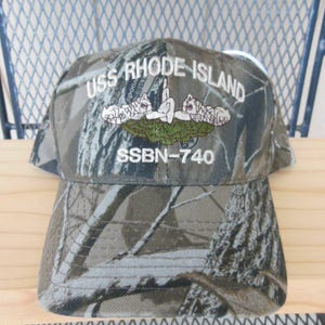 May include: Camouflage baseball cap with the text "USS RHODE ISLAND SSBN-740" embroidered on the front.