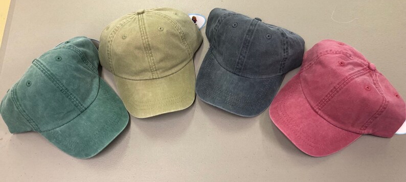 Puede incluir: Cuatro gorras de b&eacute;isbol lisas en diferentes colores: verde, caqui, azul y burdeos.