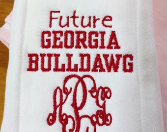 May include: White burp cloth with red embroidery that reads "Future Georgia Bulldog" and a monogram of the letters "P.G.C."