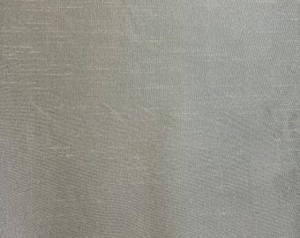 May include: A close-up of a smooth, light gray fabric with a subtle, woven texture.