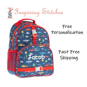 May include: A blue backpack with a pattern of cars, planes, and trees. The backpack has red accents, a side mesh pocket, and the name "Jacob" printed on the front. The text "Inspiring Stitches" is at the top.