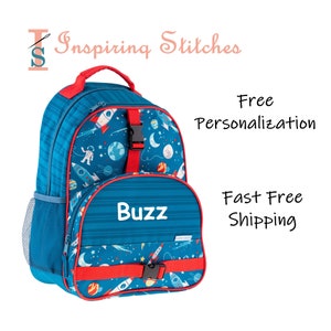 May include: Blue and red backpack with a space theme featuring rockets, planets, and an astronaut. The backpack has a personalized name tag that says "Buzz".