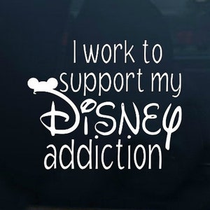 May include: White vinyl decal with the text "I work to support my Disney addiction". The text is in a stylized font with a Mickey Mouse head graphic.