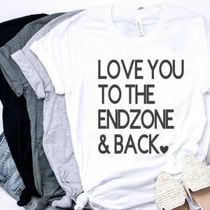 May include: White t-shirt with black text that reads "Love you to the endzone & back" with a small heart symbol.