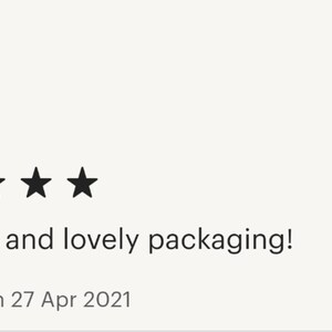 May include: A five-star review with the text "Great tea and lovely packaging!" and "Reviewed on 27 Apr 2021". The image shows a brown paper bag with a logo and text on it.