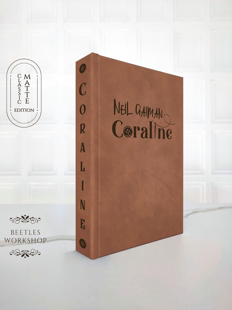 minimalist vegan leather hardcover of Coraline by Neil Gaiman front view,
custom rebound Coraline book aesthetic brown matte cover with button detail