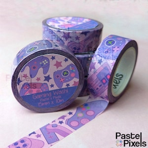 Peut inclure: Quatre rouleaux de ruban adhésif washi violet et rose sur le thème du jeu. Le ruban présente un motif de manettes de jeu violettes, d'étoiles roses et de signes plus blancs sur un fond rose clair. Le ruban est étiqueté "Gaming Washi Pastel x Pixels 15mm x 10m".