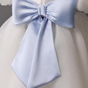 personalized first communion dress, custom flower girl dress, embroidered belt dress, first holy communion outfit, heirloom dress for girls, embroidered sash dress, ivory dress with monogram, white dress with big bow, special occasion dress girl, birthday dress with embroidered sash, wedding dress for young girls, flower girl dress with ribbon bow, baptism dress with embroidered belt