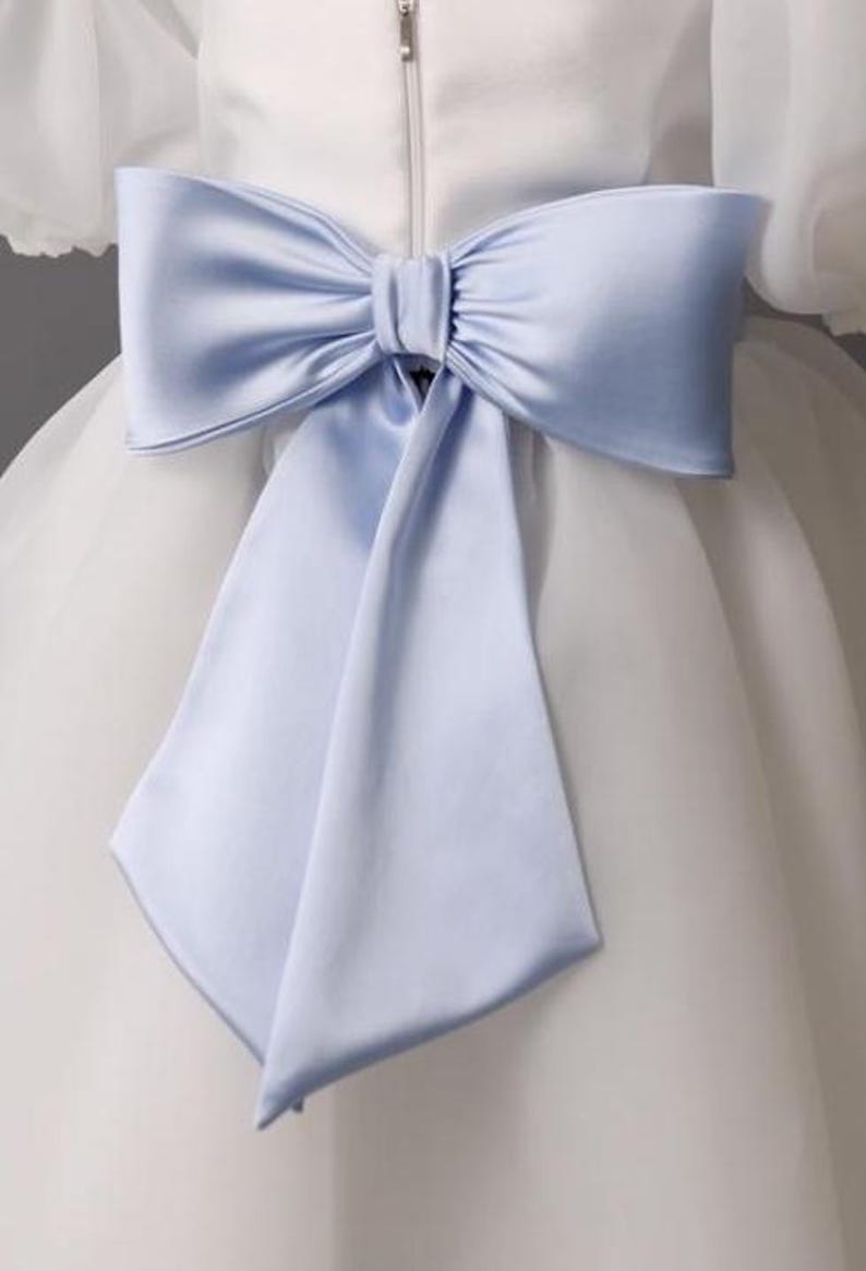 personalized first communion dress, custom flower girl dress, embroidered belt dress, first holy communion outfit, heirloom dress for girls, embroidered sash dress, ivory dress with monogram, white dress with big bow, special occasion dress girl, birthday dress with embroidered sash, wedding dress for young girls, flower girl dress with ribbon bow, baptism dress with embroidered belt
