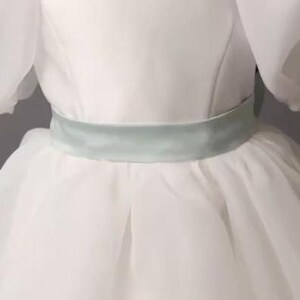 personalized first communion dress, custom flower girl dress, embroidered belt dress, first holy communion outfit, heirloom dress for girls, embroidered sash dress, ivory dress with monogram, white dress with big bow, special occasion dress girl, birthday dress with embroidered sash, wedding dress for young girls, flower girl dress with ribbon bow, baptism dress with embroidered belt