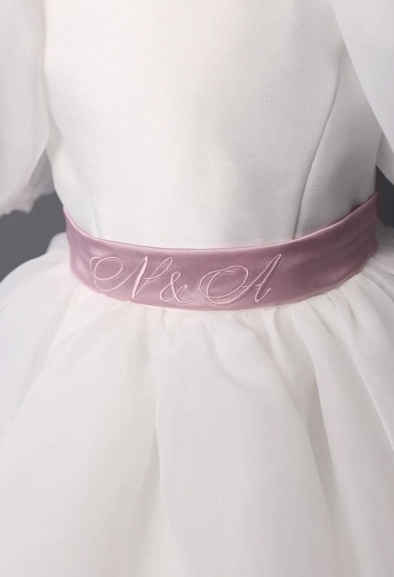 personalized first communion dress, custom flower girl dress, embroidered belt dress, first holy communion outfit, heirloom dress for girls, embroidered sash dress, ivory dress with monogram, white dress with big bow, special occasion dress girl, birthday dress with embroidered sash, wedding dress for young girls, flower girl dress with ribbon bow, baptism dress with embroidered belt