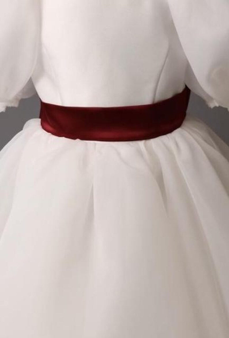 personalized first communion dress, custom flower girl dress, embroidered belt dress, first holy communion outfit, heirloom dress for girls, embroidered sash dress, ivory dress with monogram, white dress with big bow, special occasion dress girl, birthday dress with embroidered sash, wedding dress for young girls, flower girl dress with ribbon bow, baptism dress with embroidered belt