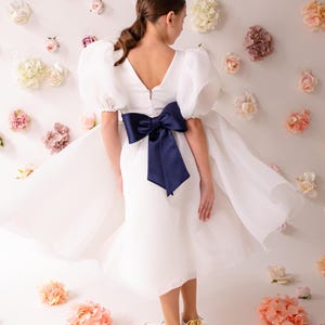 personalized first communion dress, custom flower girl dress, embroidered belt dress, first holy communion outfit, heirloom dress for girls, embroidered sash dress, ivory dress with monogram, white dress with big bow, special occasion dress girl, birthday dress with embroidered sash, wedding dress for young girls, flower girl dress with ribbon bow, baptism dress with embroidered belt