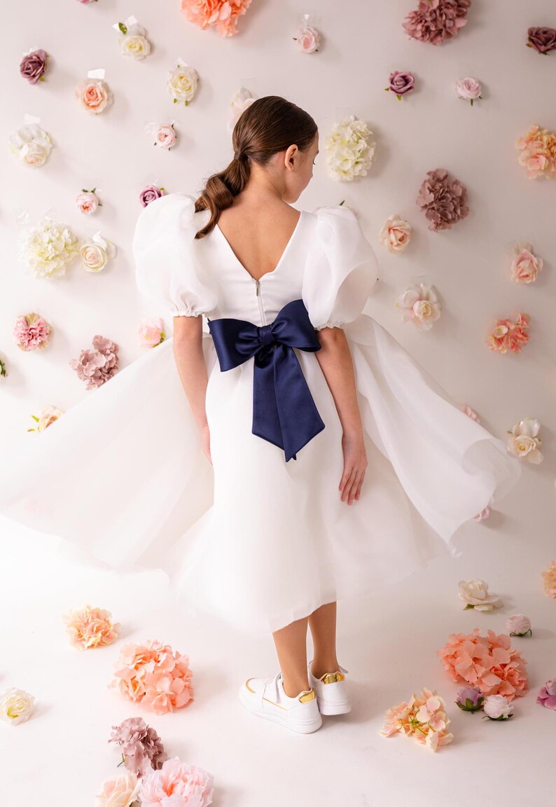 personalized first communion dress, custom flower girl dress, embroidered belt dress, first holy communion outfit, heirloom dress for girls, embroidered sash dress, ivory dress with monogram, white dress with big bow, special occasion dress girl, birthday dress with embroidered sash, wedding dress for young girls, flower girl dress with ribbon bow, baptism dress with embroidered belt