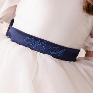 personalized first communion dress, custom flower girl dress, embroidered belt dress, first holy communion outfit, heirloom dress for girls, embroidered sash dress, ivory dress with monogram, white dress with big bow, special occasion dress girl, birthday dress with embroidered sash, wedding dress for young girls, flower girl dress with ribbon bow, baptism dress with embroidered belt