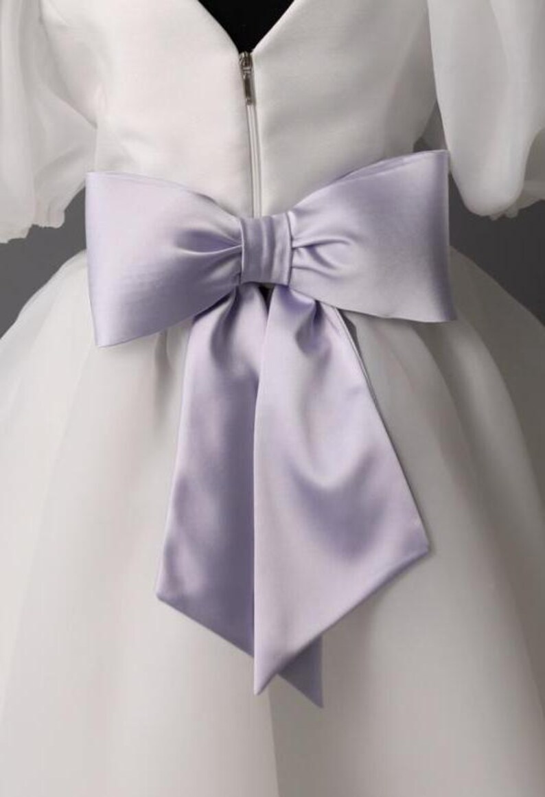 personalized first communion dress, custom flower girl dress, embroidered belt dress, first holy communion outfit, heirloom dress for girls, embroidered sash dress, ivory dress with monogram, white dress with big bow, special occasion dress girl, birthday dress with embroidered sash, wedding dress for young girls, flower girl dress with ribbon bow, baptism dress with embroidered belt