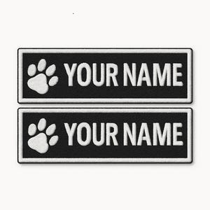May include: Two rectangular black patches with white embroidered borders. Each patch features a white paw print icon on the left side and the white text "YOUR NAME" on the right side, presented in a clean, bold, sans-serif font style.