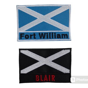Pode incluir: Duas etiquetas retangulares. A etiqueta superior é azul com uma cruz branca e o texto "Fort William" em preto. A etiqueta inferior é preta com uma cruz branca e o texto "BLAIR" em vermelho.