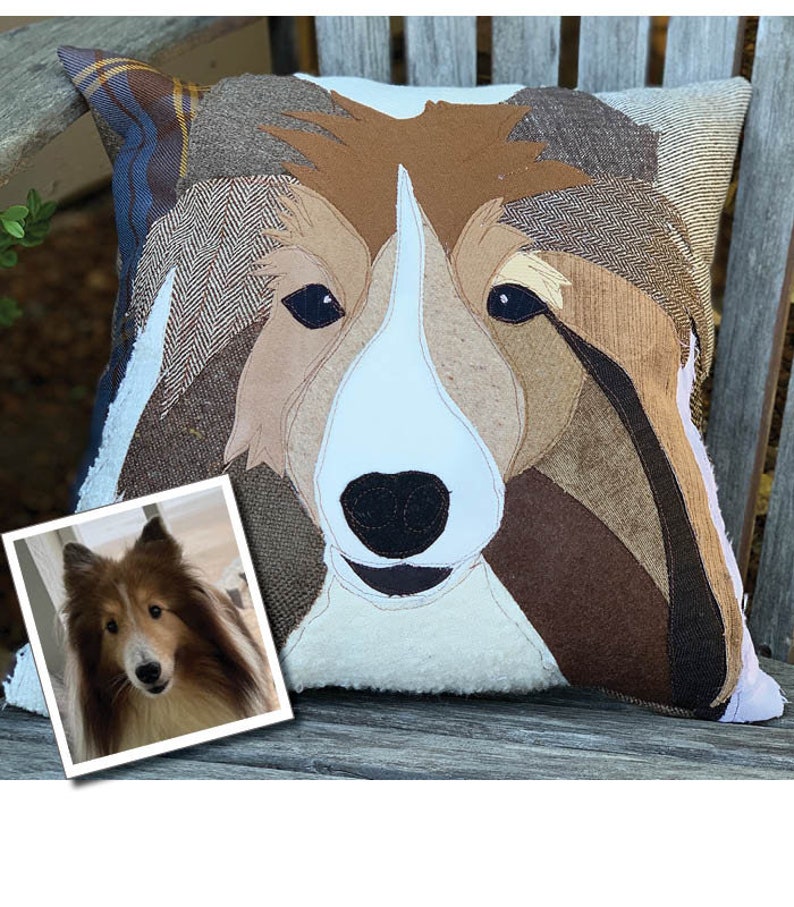 May include: A decorative pillow featuring a dog's face, crafted from various fabric textures and colors. The dog's face is primarily brown, white, and black, with a detailed patchwork design. A framed photo of the dog is in the lower left corner.