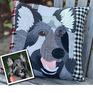 May include: A decorative dog-themed pillow featuring a patchwork design of a dog's face in shades of gray, black, and brown. The pillow has a black and white houndstooth pattern on one side and a red plaid pattern on the other. A framed photo of a dog is in the corner.