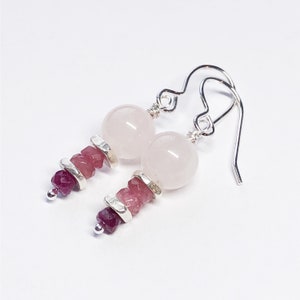May include: Silver earrings with a pink rose quartz bead and a stack of pink and red gemstone beads.