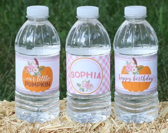 May include: Three clear plastic water bottles with labels. The labels are pink and white with a pumpkin design and floral accents. The labels read "our little pumpkin", "Sophia", and "happy birthday".