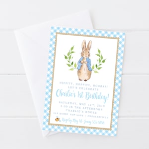 May include: A blue and white gingham patterned invitation with a watercolour illustration of Peter Rabbit wearing a blue jacket. The text reads "Hippity, Hoppity, Hooray! Let's Celebrate Charlie's 1st Birthday! Saturday, May 12th, 2018 2:00 in the afternoon Charlie's House 555 Bunny Hop Lane | Chesterfield R.S.V.P. by May 1st Jenny 555-5555"