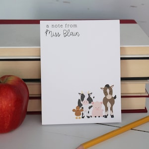 May include: A white notepad with the text "a note from Miss Blain" at the top. The notepad has a cartoon illustration of a cow, pig, horse, and chicken at the bottom.