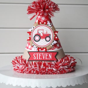 May include: Red and white checkered birthday party hat with a red tractor graphic and the name "STEVEN" on the front.
