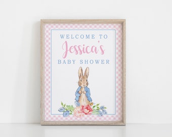 May include: A pink and blue gingham baby shower sign with the text "Welcome to Jessica's Baby Shower" and a cartoon image of Peter Rabbit.